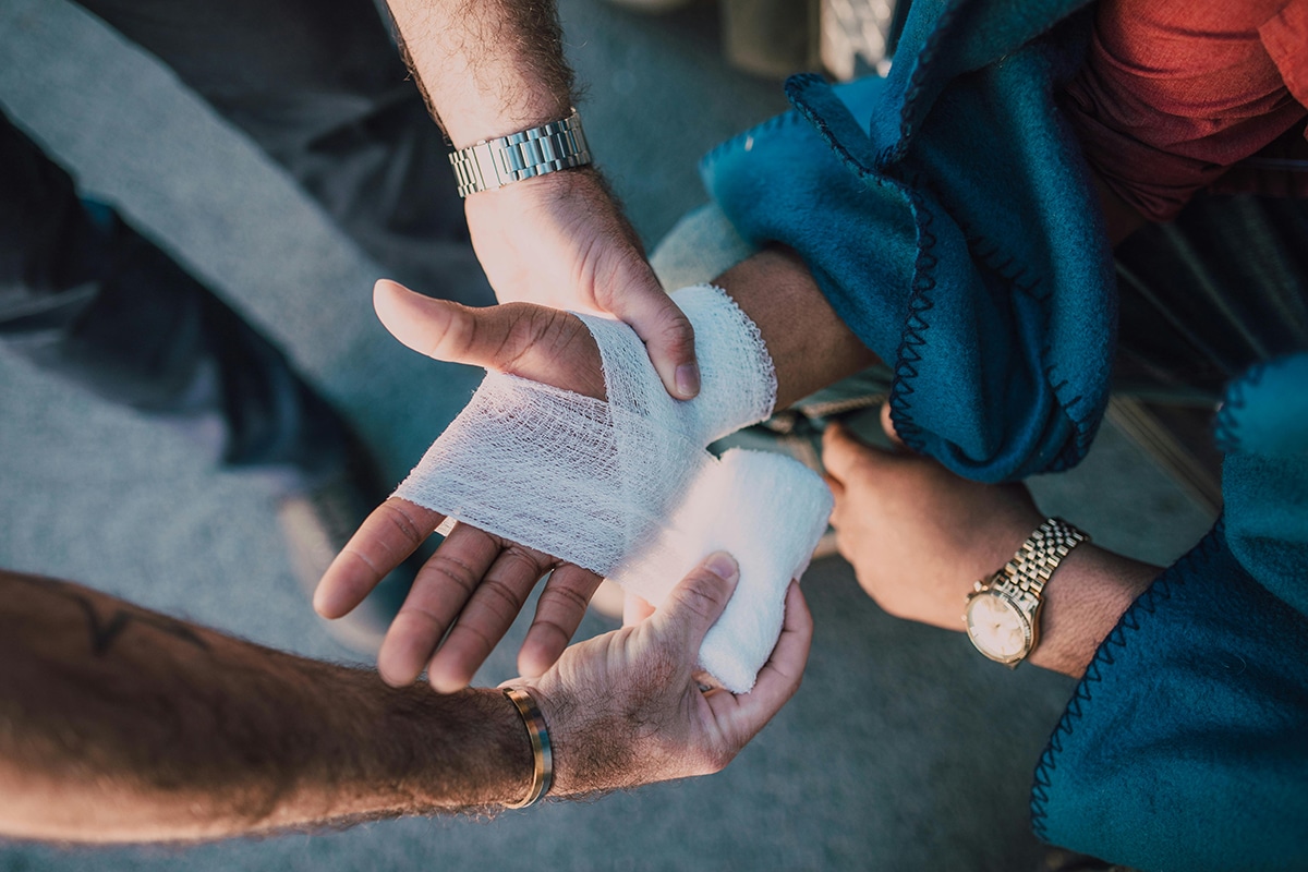 close up shot of individual getting bandaged on their hand